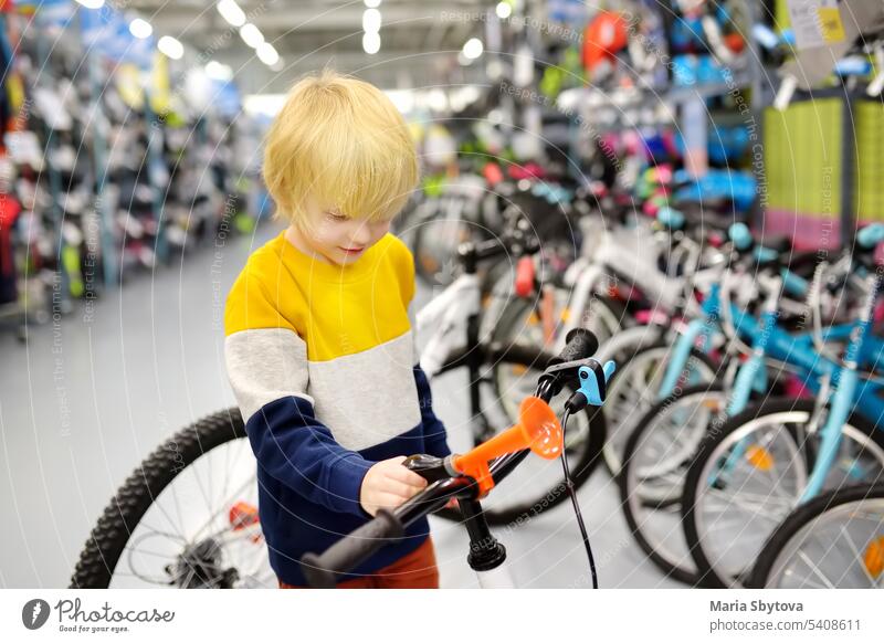 Little boy choosing bicycle in sport store. chose bike kid shop preschooler protection child buy buyer shopping buying caucasian check choice choose commerce