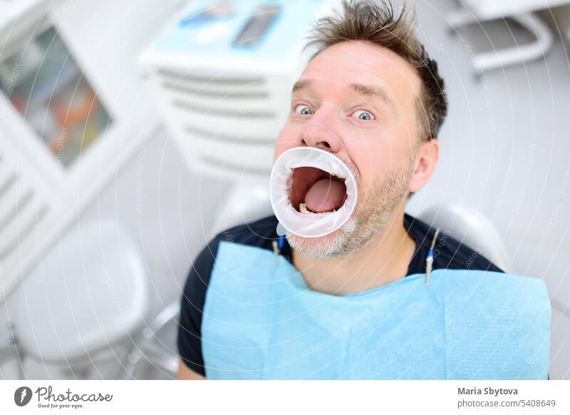 Frightened patient in the chair on dental clinic. Orthodontist and prosthetics appointment. Fear of dentists concept. treat teeth fear fright cavity funny mouth