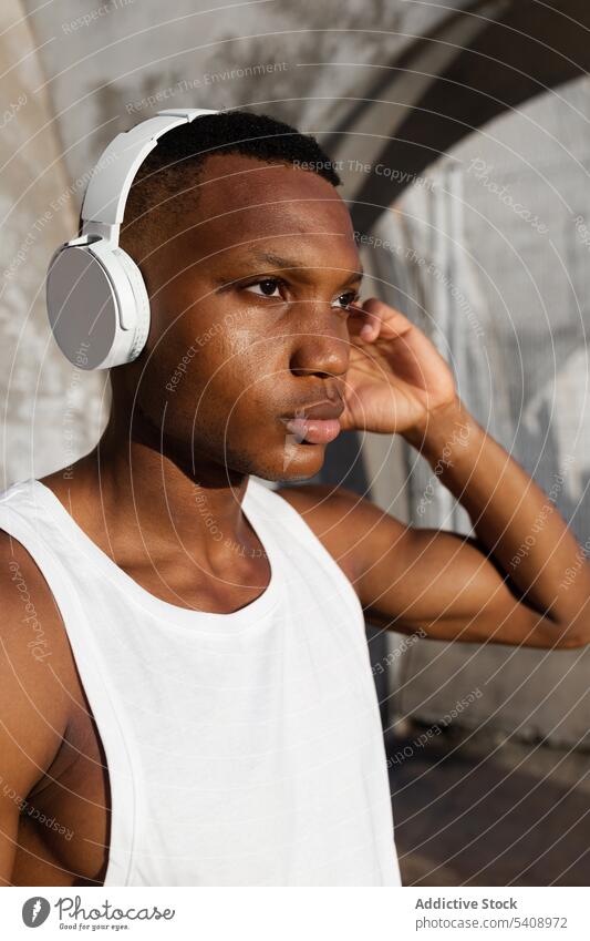 Black serious man listening to music in headphones relax song athlete wireless sound male rest audio melody wellness tune concentrate wellbeing break black guy