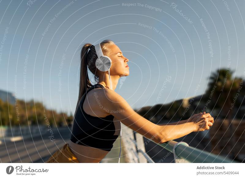 Young woman resting after working out outdoors at sunset young jogger athlete runner running sport healthy fit fitness athletic training workout exercise