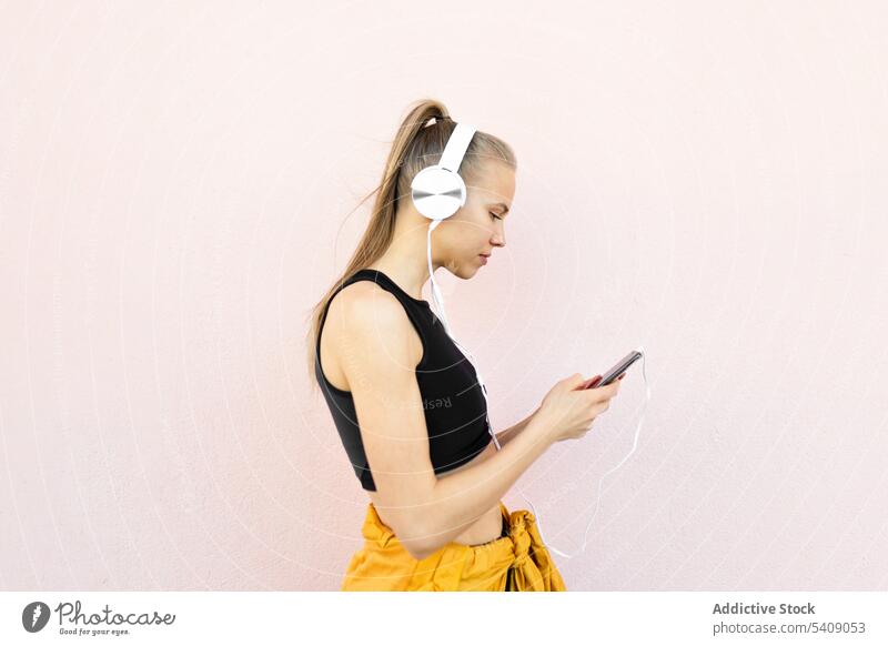 Young woman listening to music on the phone isolated on bright background young jogger headphones athlete runner running sport healthy fit fitness athletic