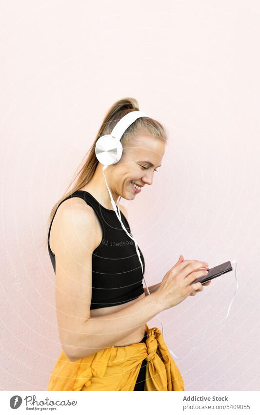Young woman listening to music on the phone isolated on bright background young jogger headphones athlete runner running sport healthy fit fitness athletic