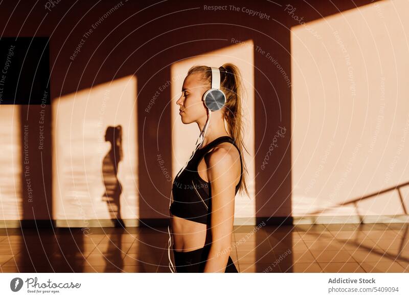 Young athletic caucasian listening to music at sunset young woman jogger athlete runner running sport healthy fit fitness training workout exercise lifestyle