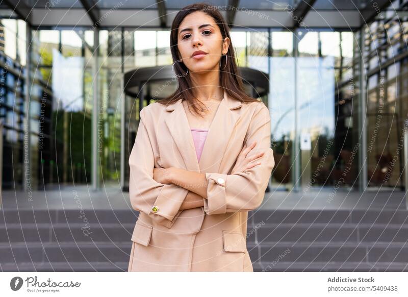 Dreamy businesswoman standing on street entrepreneur pensive thoughtful manager building downtown self assured leader Middle Eastern ethnic confident female