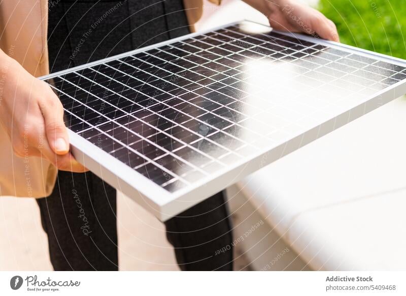 Crop woman with portable solar panel battery energy wireless power eco ecology street reflection sunlight using modern urban touch electric alternative sunshine