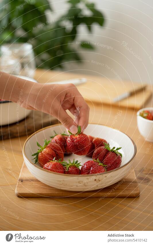 Crop woman holding strawberry in bowl over wooden table person take ripe food fresh jam sweet prepare fruit tasty delicious vitamin eat ingredient dessert piece