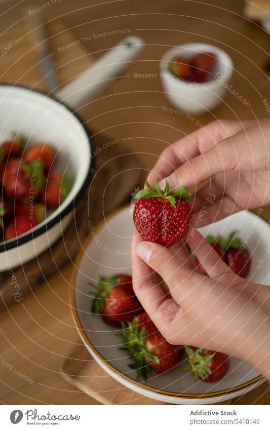 Crop person with strawberry in hands above bowl table handful fresh ripe vitamin delicious fruit natural organic demonstrate healthy food tasty show leaf sweet
