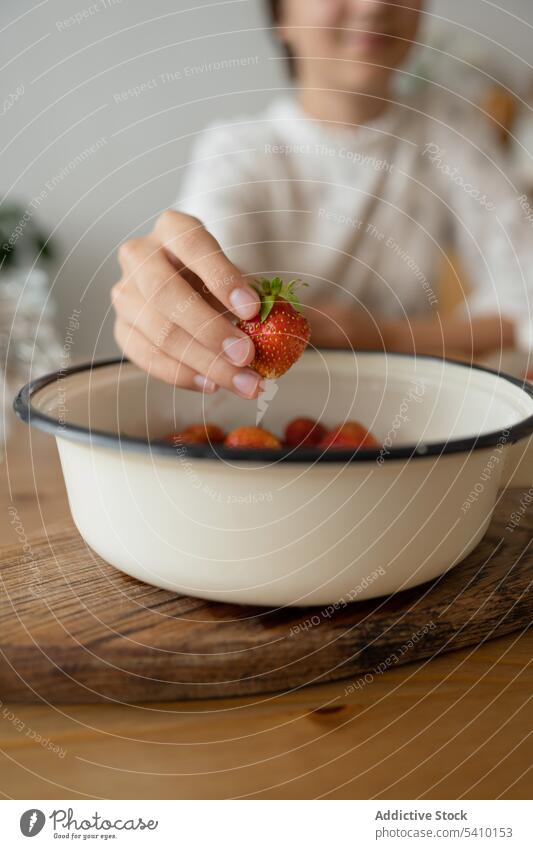 Crop woman picking strawberry from bowl over table hand delicious fruit fresh healthy food cafe yummy sweet organic young vitamin tasty ripe lady red juice