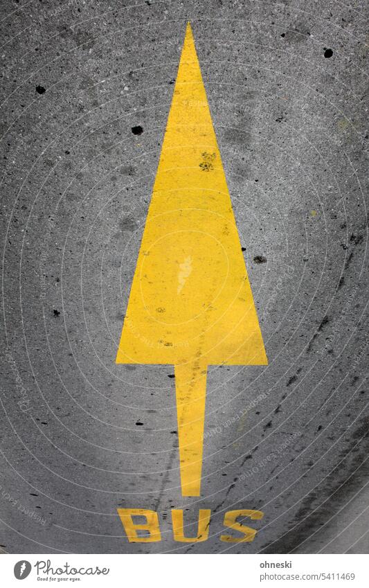 Yellow arrow and yellow bus inscription on road Arrow Bus Lane markings Street Asphalt Traffic infrastructure Signs and labeling Traffic lane Orientation