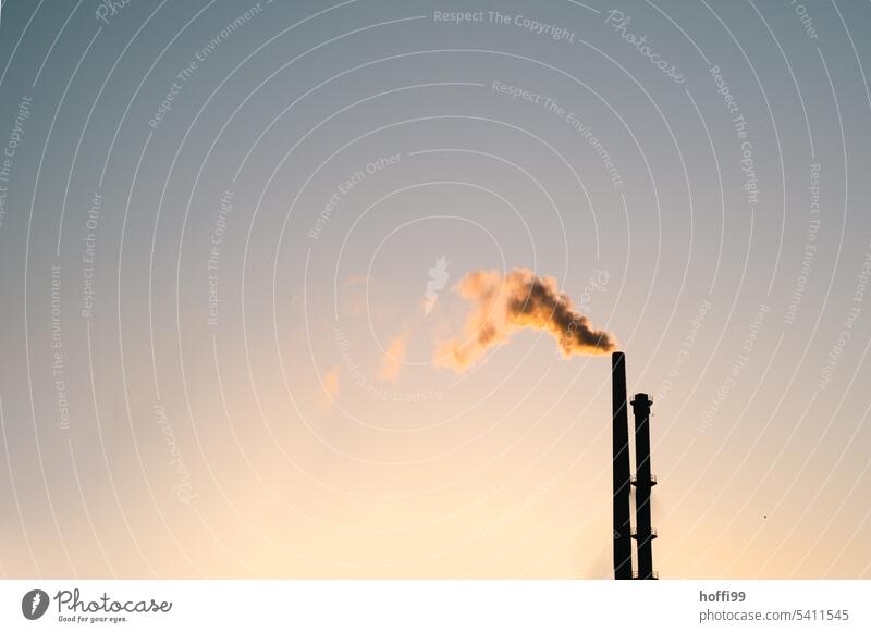 minimalist view of two chimneys at sunrise or sunset. Chimney Exhaust gas Emission Air pollution Beautiful weather Industrial plant Sunrise Sunset Sunlight