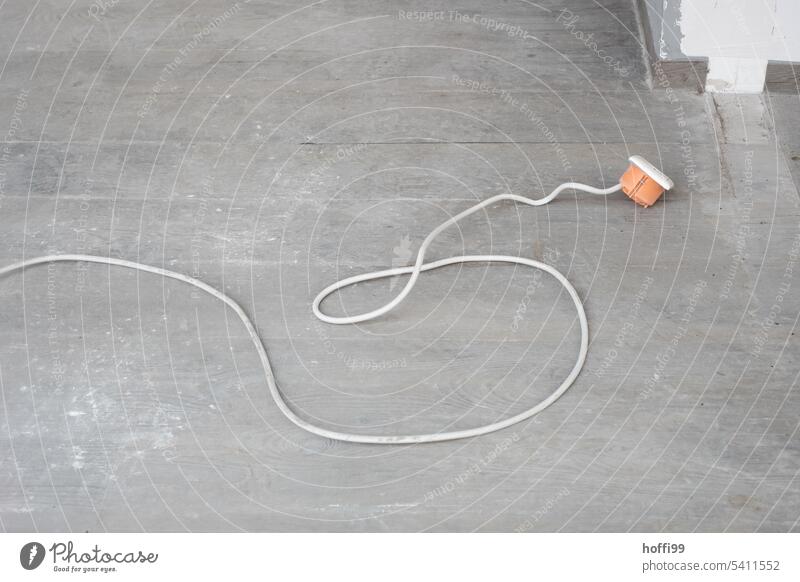 Cable with ripped out flush-mounted box on concrete floor electrical installation Building for demolition torn out Construction site Electricity Decline