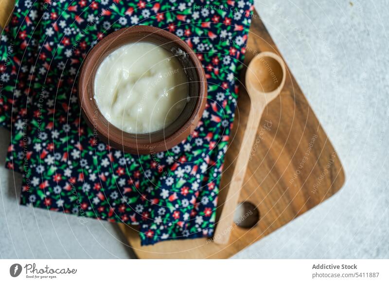 Traditional serving of Georgian sour yogurt known as Matsoni in clay pot georgian traditional dessert culture matsoni spoon wooden rustic colorful napkin