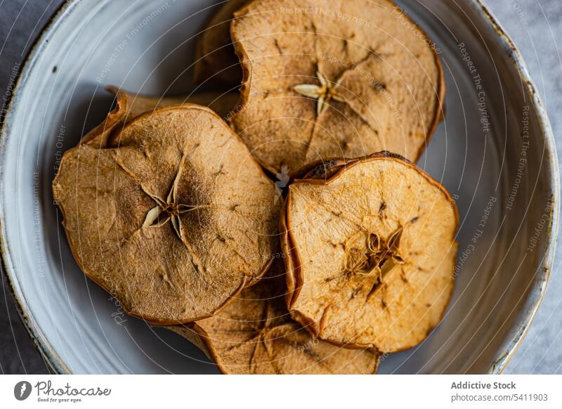 Slices of dried apples in bowl slice fruit plate ceramic high angle from above blur blurred background many taste tasty yummy delicious healthy nutrient