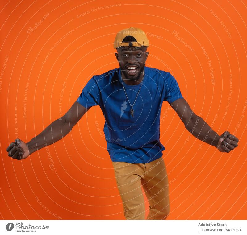 Cheerful African American with round cap dancing man smile dance style happy cheerful gesture casual glad optimist fun excited hip hop fashion active move