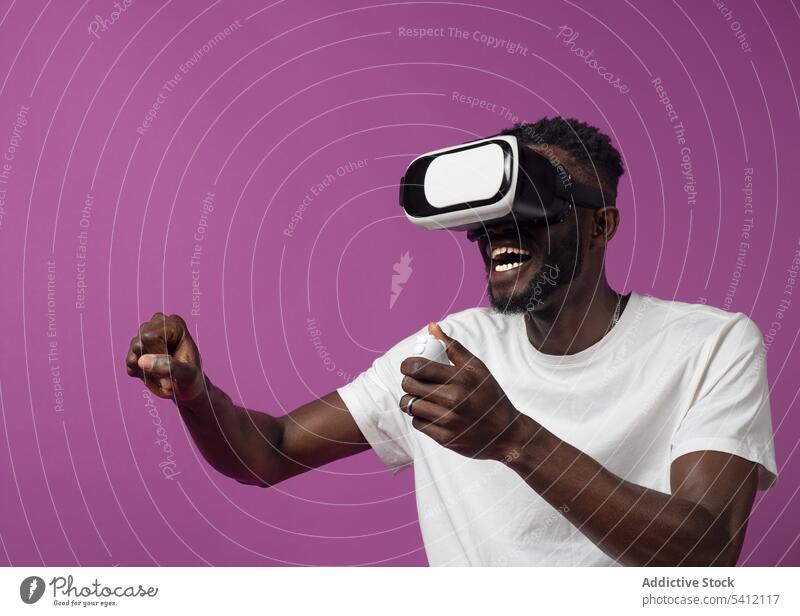 Joyful young black man watching video on virtual reality headset excited controller videogame goggles experience entertain male gadget african american ethnic