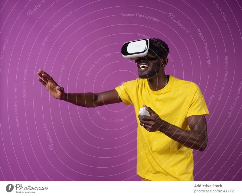 Joyful young black man watching movie on virtual reality headset excited controller videogame goggles experience entertain male gadget african american ethnic