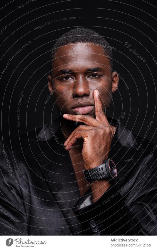 Serious black man with wristwatch serious thoughtful pensive elegant well dressed classy formal ponder male think contemplate wistful individuality accessory