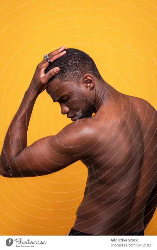Sensual black man with naked torso touching forehead serious masculine shirtless confident touch chin portrait macho appearance individuality sensual