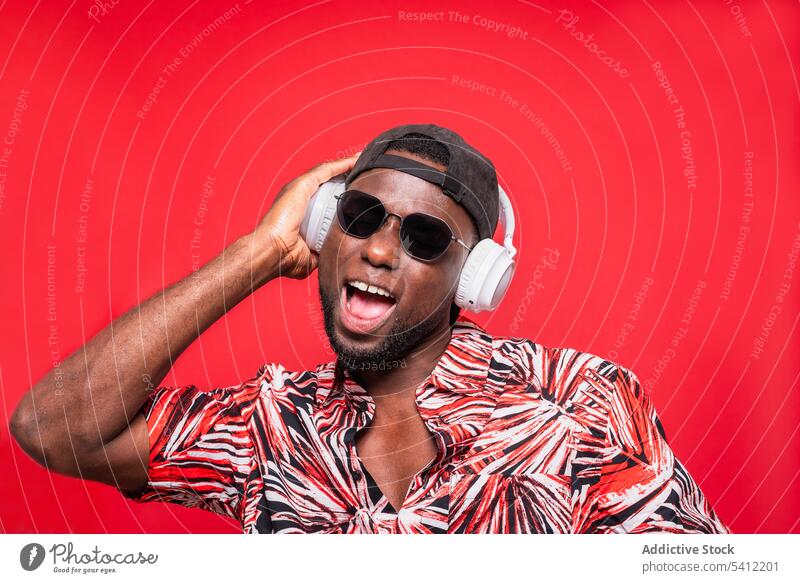 Happy black man in sunglasses and headphones - a Royalty Free Stock Photo  from Photocase