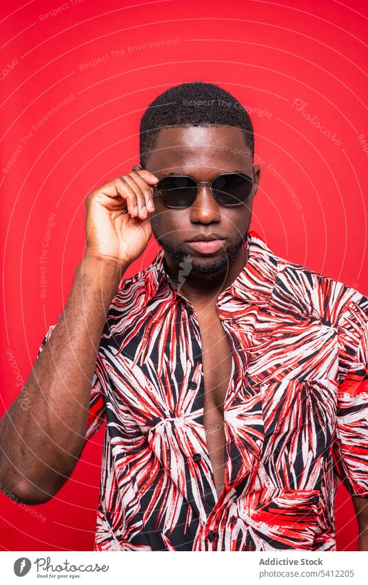 Stylish black man in sunglasses tropical shirt trendy fashion confident outfit appearance portrait style model male african american serious individuality