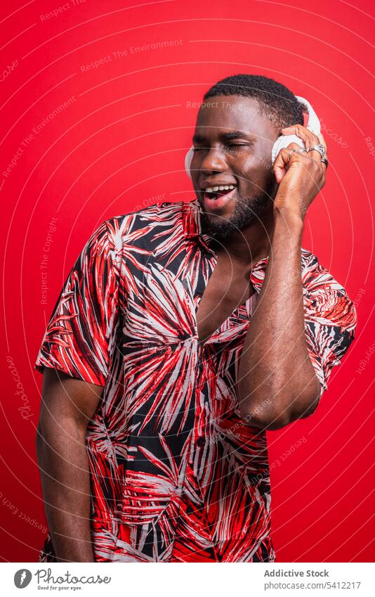 Happy African American man listening to music enjoy sing song wireless earphones playlist using true wireless positive optimist happy sound audio melody casual