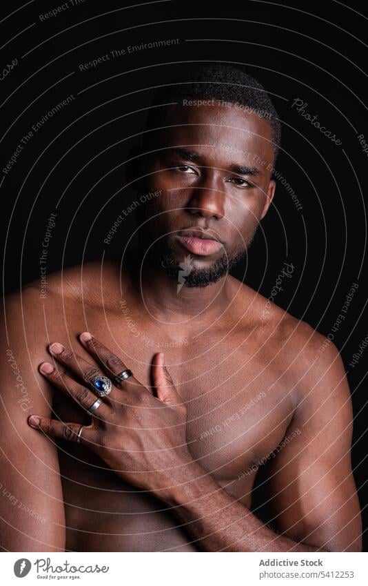 Serious black man with naked torso looking at camera sportsman athlete muscular shirtless portrait macho confident masculine strong male ethnic muscle model