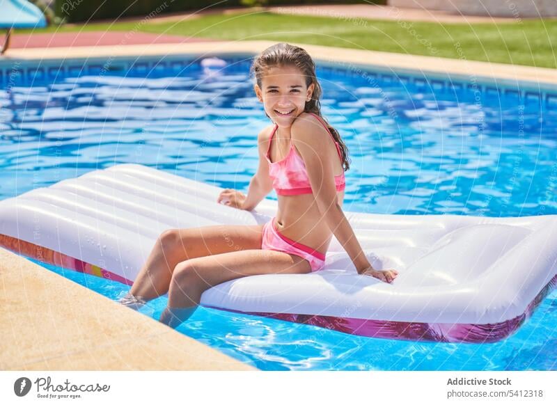 Cute girl resting on inflatable pool bed while taking sunbath on pool child vacation swim relax resort kid summer enjoy holiday weekend cute chill sit water