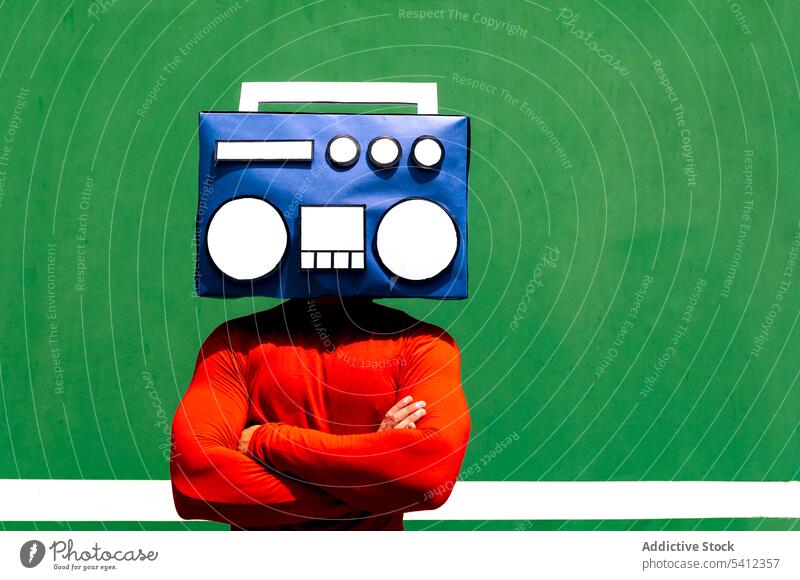 Anonymous person covering face with blue boombox man listen music radio cover face arms crossed red hide cool bright individuality green casual color vivid
