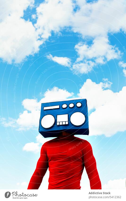 Anonymous man covering face with boombox under sky cover face listen music leisure carefree hobby retro vintage blue sky red freedom cloudy casual male hide
