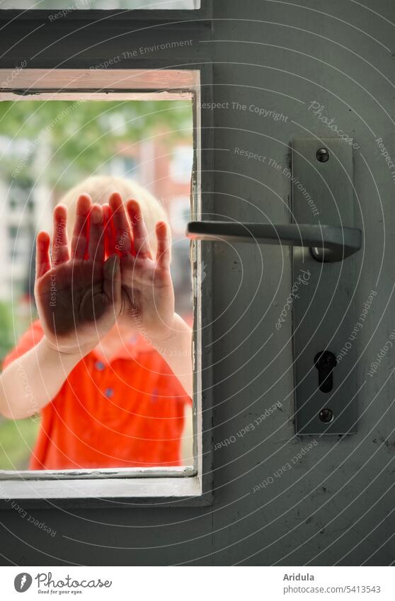 Child presses his hands against the glass of a closed front door Closed Pushing Cover face Palm of the hand door handle Entrance Front door Door handle locked