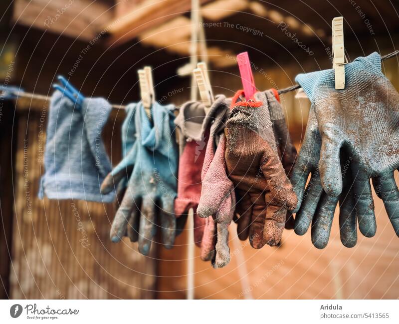 Garden gloves and a washcloth hanging on a clothesline gardening gloves Gloves Gardening work Gardener Clothes peg Old Broken Worn out
