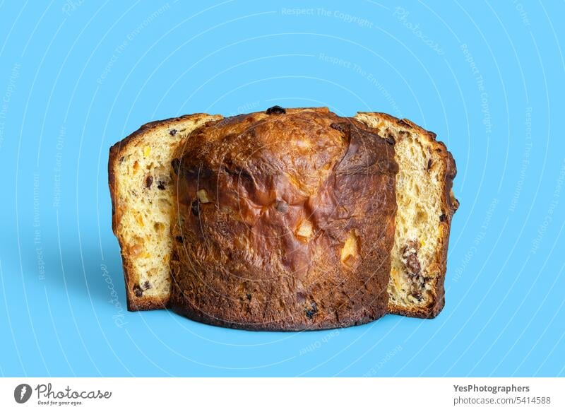 Sliced panettone isolated on a blue background. Homemade sourdough panettone baked bread bright brown cake candied celebration chocolate christmas color concept