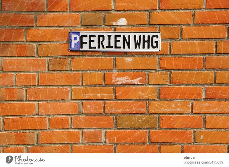 Sign - P FERIENWHG - on a red brick wall Vacation home Parking lot Hospitality Special right Reserved Guest parking Blog Vacation spot sign Red vacation