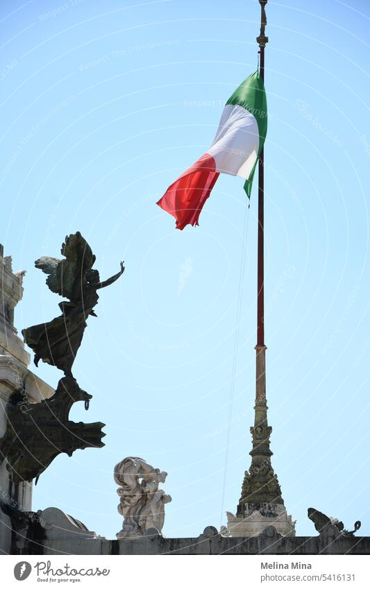 Italian flag on blue sky with an angel statue Flag Italy red white green flag Blue sky flag on background italian architecture Statue Angel figure touching