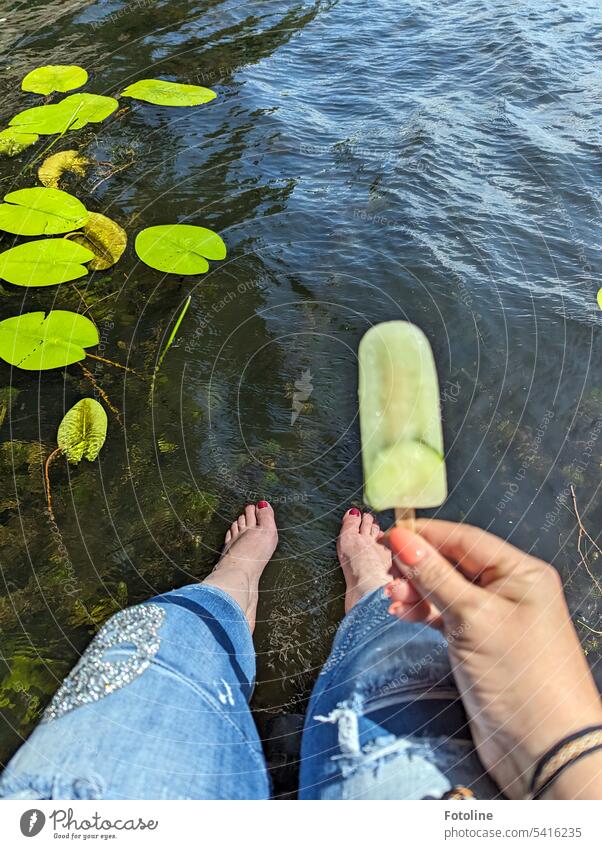 Well, I'm going to give you another taste of summer. I'm sitting on a jetty by the water, letting my feet dangle and holding a delicious ice cream on a stick in my hand. There are gentle waves on the water and water lily pads are gently drifting.