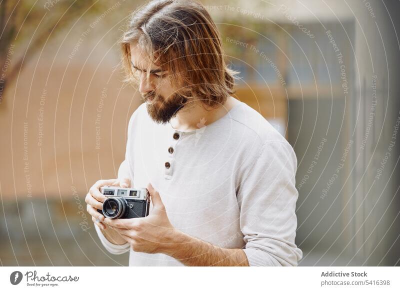 Handsome man setting up camera in hand handsome taking photo black pensive photographer mustache stubble adult hat lifestyle photographing bearded model network