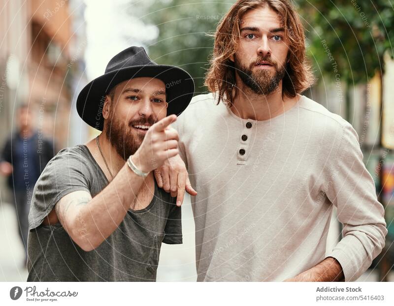 Handsome men standing in street and watching pointing friendship mustache smiling adult handsome lifestyle together showing stubble bearded model young