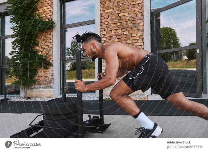 Black guy pulling weights in outdoor gym man sport african american athlete workout fitness male black ethnic equipment building exterior young muscular