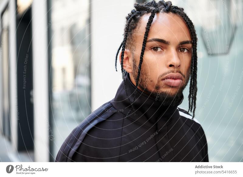 African American male standing on the street man ethnic braided young african american person handsome attractive displeased pensive thoughtful serious