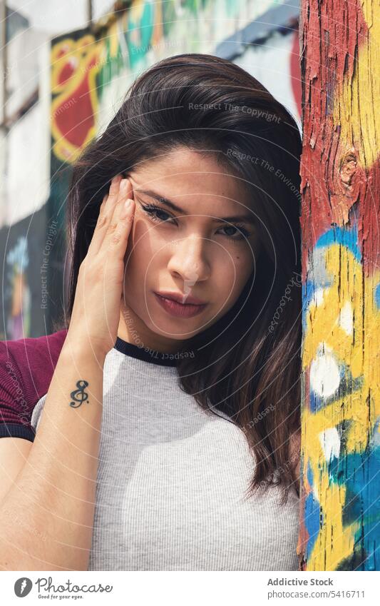 Woman standing near graffiti wall woman pretty young beautiful concept style brick urban city female brunette attractive person beauty adult cute lifestyle lady