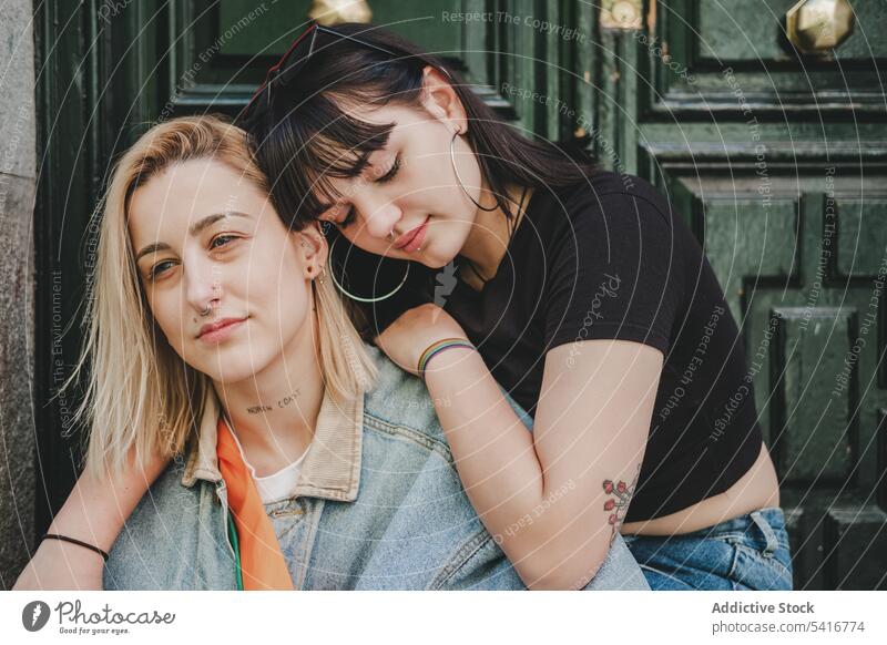 Lesbian couple sitting near door lesbian embracing women love street city building young casual closed eyes hugging tender homosexual lgbt alternative together