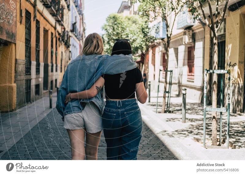 Lesbian couple hugging each other walking on street lesbian lgbt happy waving city young together women casual homosexual pride equality alternative
