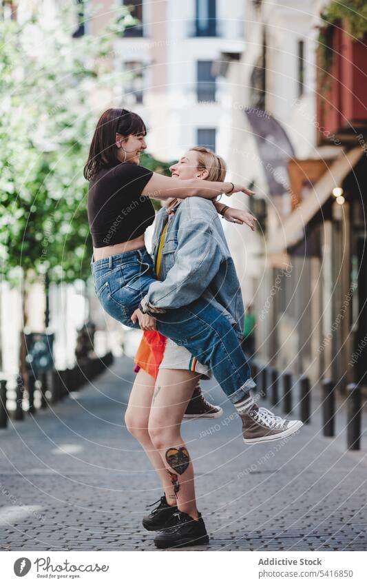 Happy lesbian couple having fun on street lgbt hugging lifting happy city young together women casual homosexual pride lap equality alternative relationship