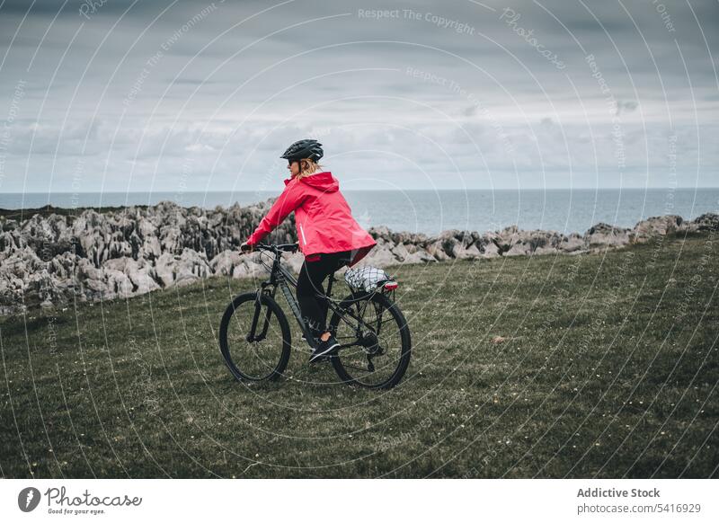 Female cyclist riding on mountain road woman bicycle helmet rocky landscape female adult person active sportive alone cycling lifestyle bike travel adventure