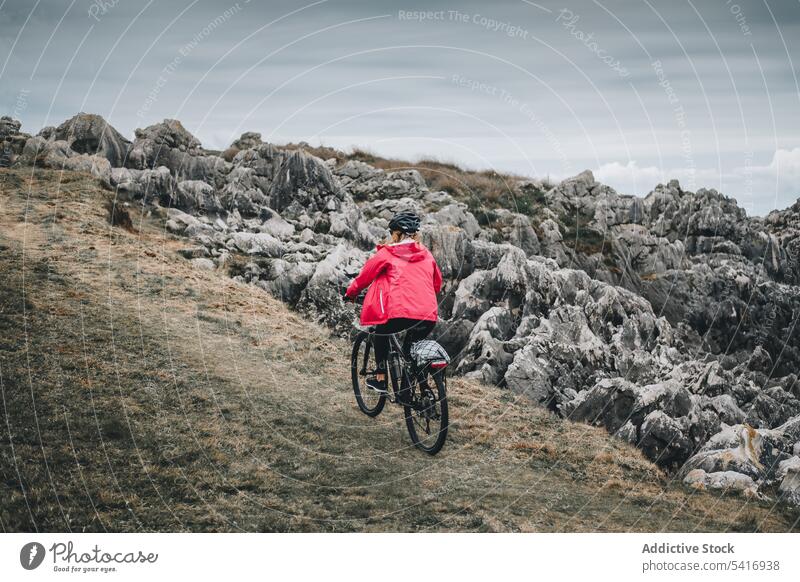 Female cyclist riding on mountain road woman bicycle helmet rocky landscape female adult person active sportive alone cycling lifestyle bike travel adventure