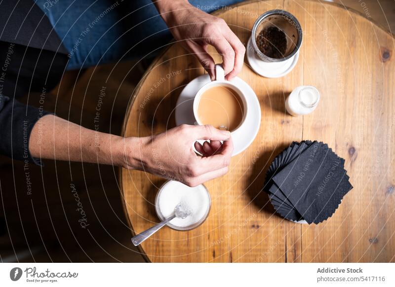 Woman with tea cup in cafe woman milk sugar hand adult female person casual jeans sitting stirring enjoying strainer fresh hot brewed mug drink beverage leisure