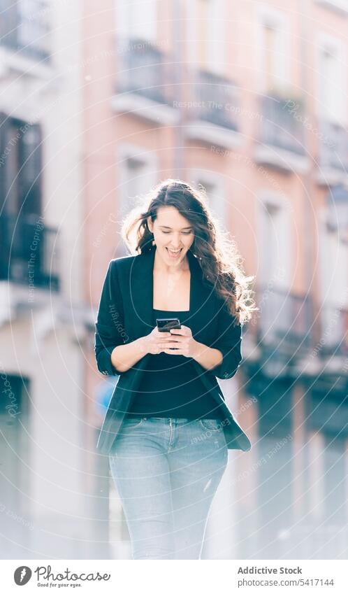 Young female walking with smartphone woman mobile talking communication young person attractive brunette beautiful pretty long hair casual relaxed happy