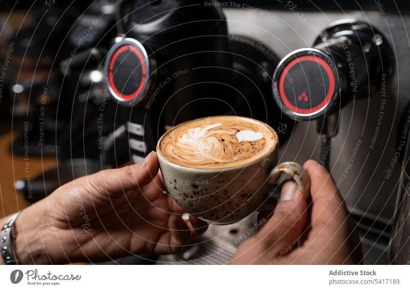 Barista making coffee with latte art barista cappuccino cup hand foam beverage pattern cafe occupation adult person professional pouring decorating hot milk