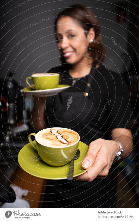 Ethnic woman with cappuccino cups barista latte art coffee cafe occupation job ethnic giving female young person professional cheerful attractive offering