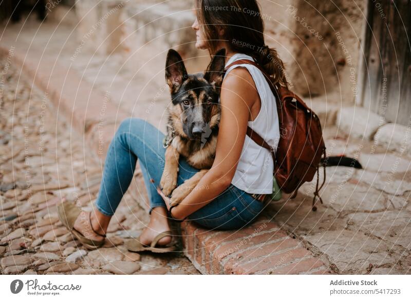 Woman with cute shepherd woman kiss street happy together dog domestic breed city companion owner animal beautiful urban pavement pet friend casual style